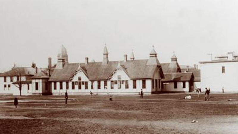 The first university-owned hospital in the nation started in the converted house at the right of this image, and was enlarged a few years later to include the wooden "pavilions" seen at left