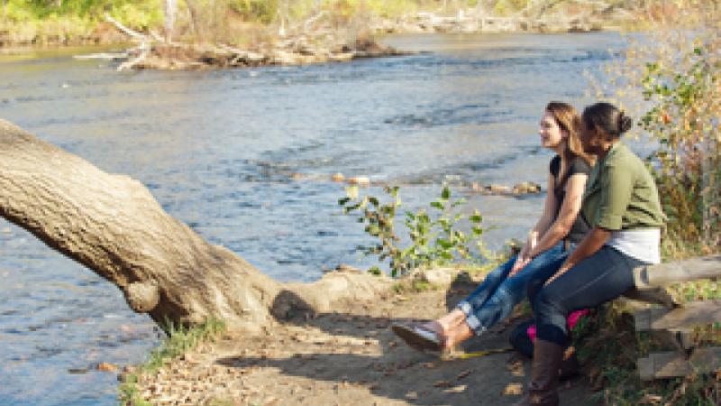 Students relax beside the Huron River
