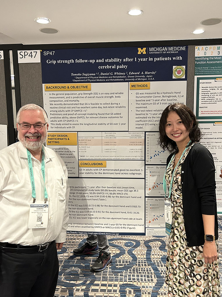 Dr. Ed Hurvitz stands with a co-investigator in front of their research poster titled "Grip strength follow-up and stability after 1 year in patients with cerebral palsy"