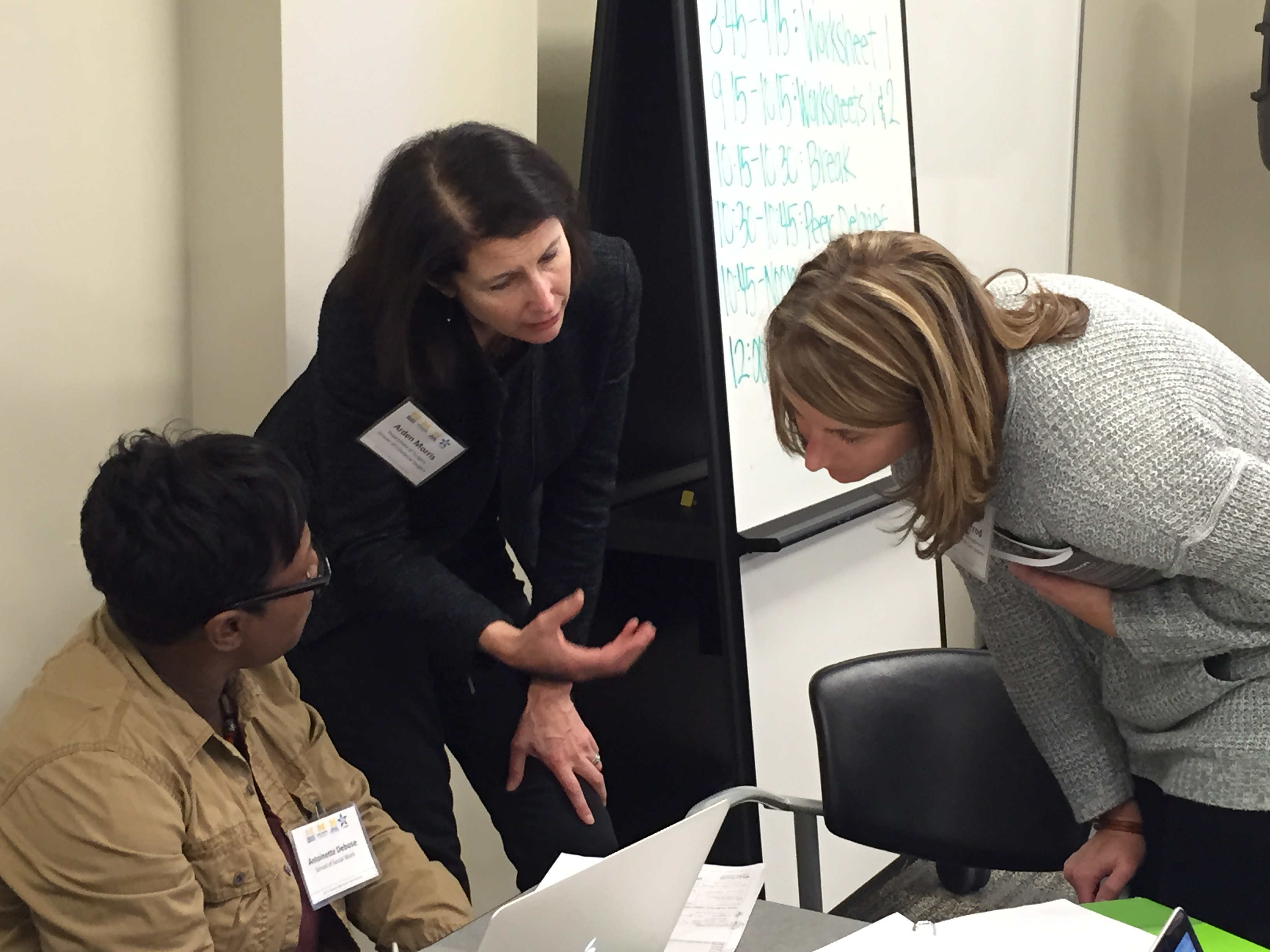 Image of three women discussing research work in small group workshop