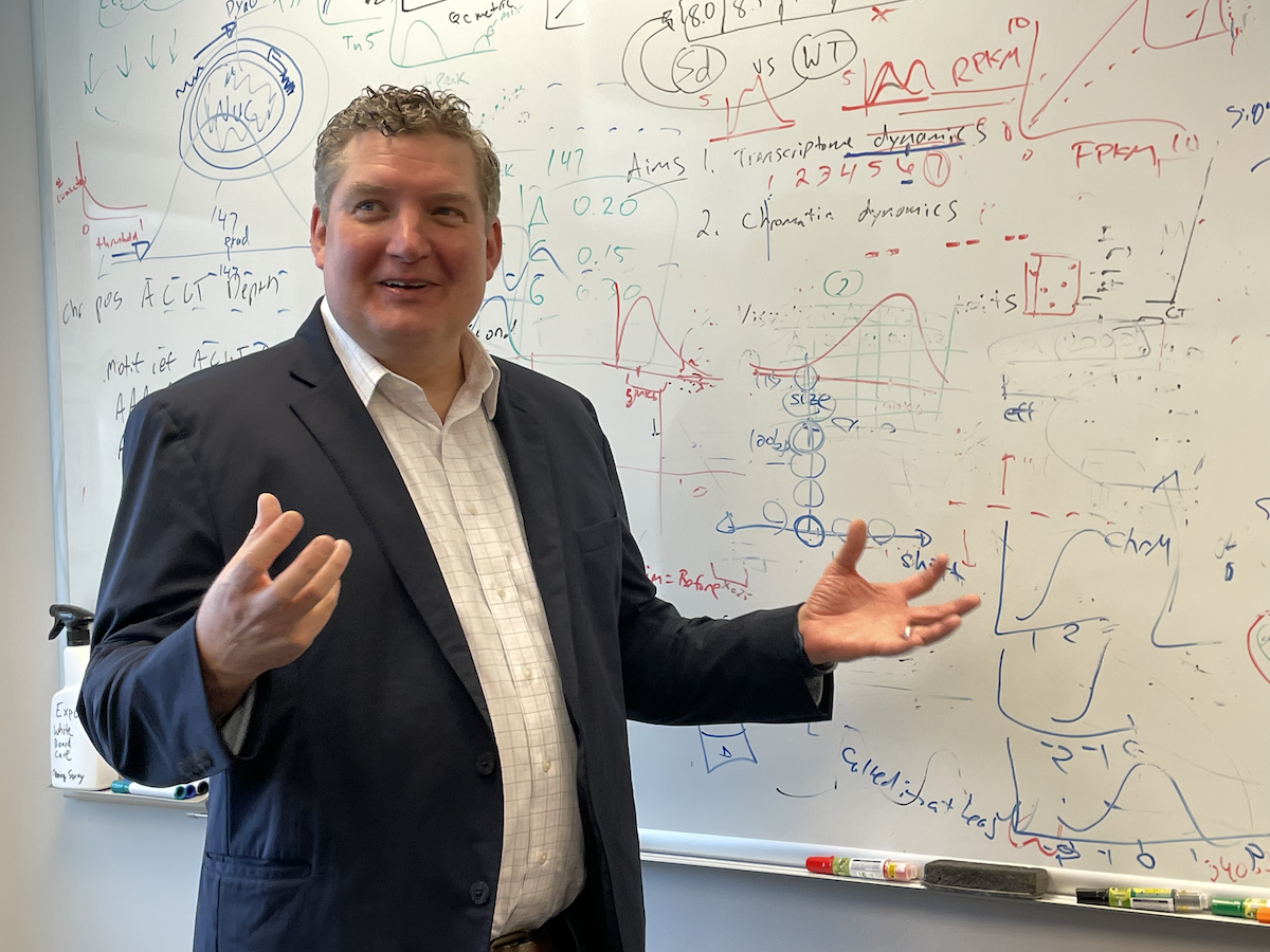 Professor Parker in front of white board with equations