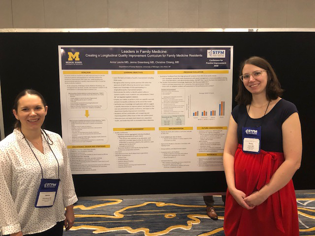 Jenna Greenberg and Anna Laurie stand on either side of a poster titled Leaders in Family Medicine: Creating a Longitudinal Quality Improvement Curriculum for Family Medicine Residents