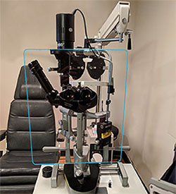Protective shield installed on a slit lamp