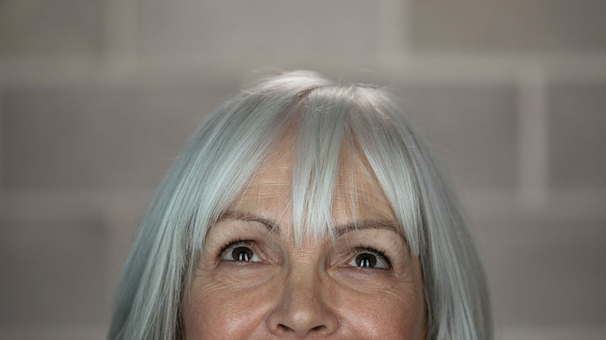 Woman with white hair looking upward