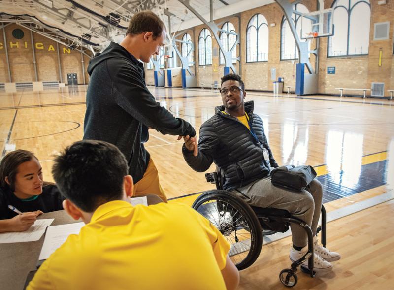 Dr. Okanlami shaking hands after wheelchair basketball practice