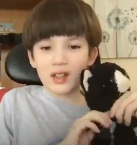 Eli, small child holding a black and white stuffed cat