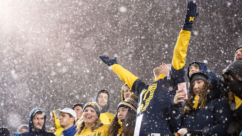 Michigan football fans cheer in the rain