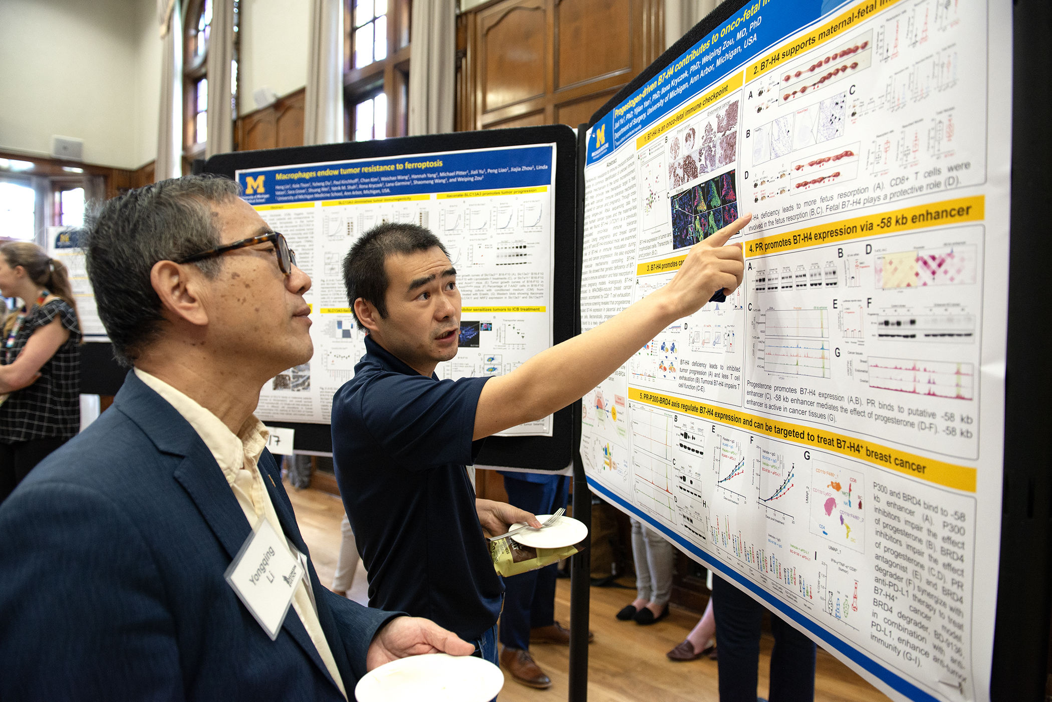 Faculty members discussing a research poster at the conference