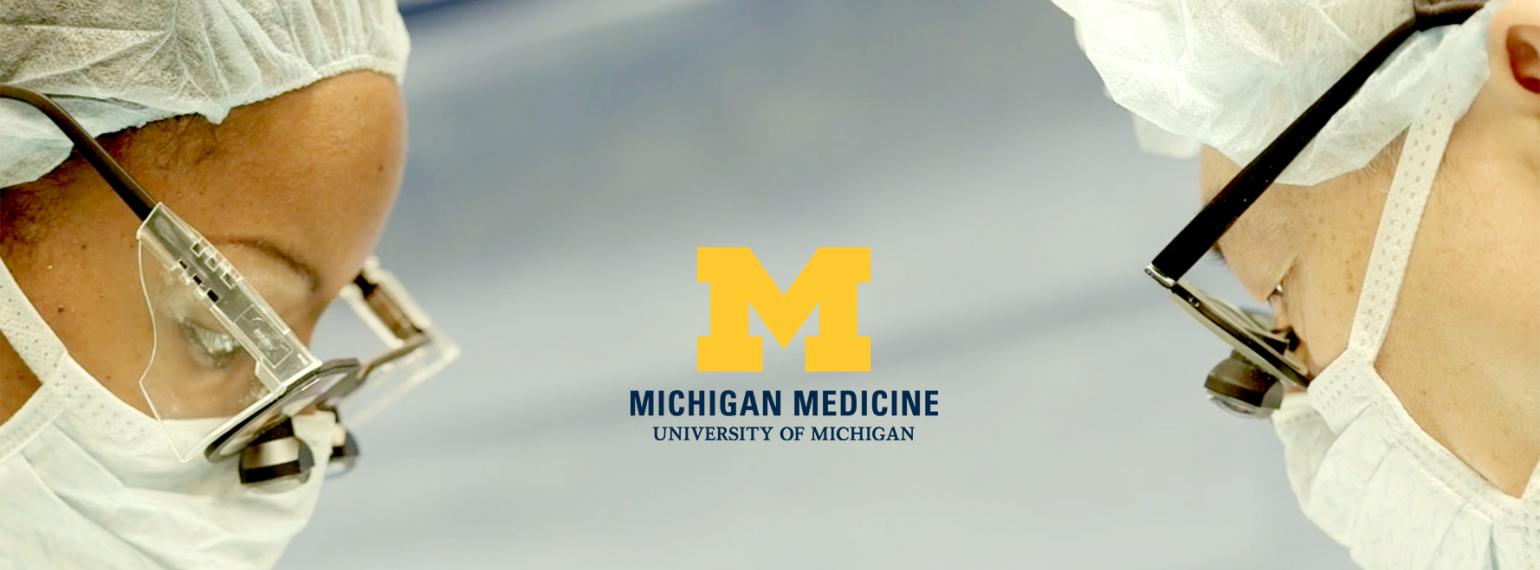Dr. Chung and surgical team member in the operating room with the Michigan Medicine logo