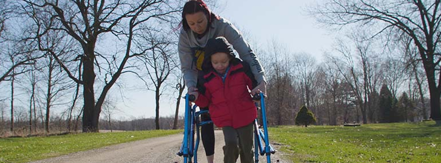 5 Year old Charlie Boike practices walking in his walker outside with his mother Lindsay Boike