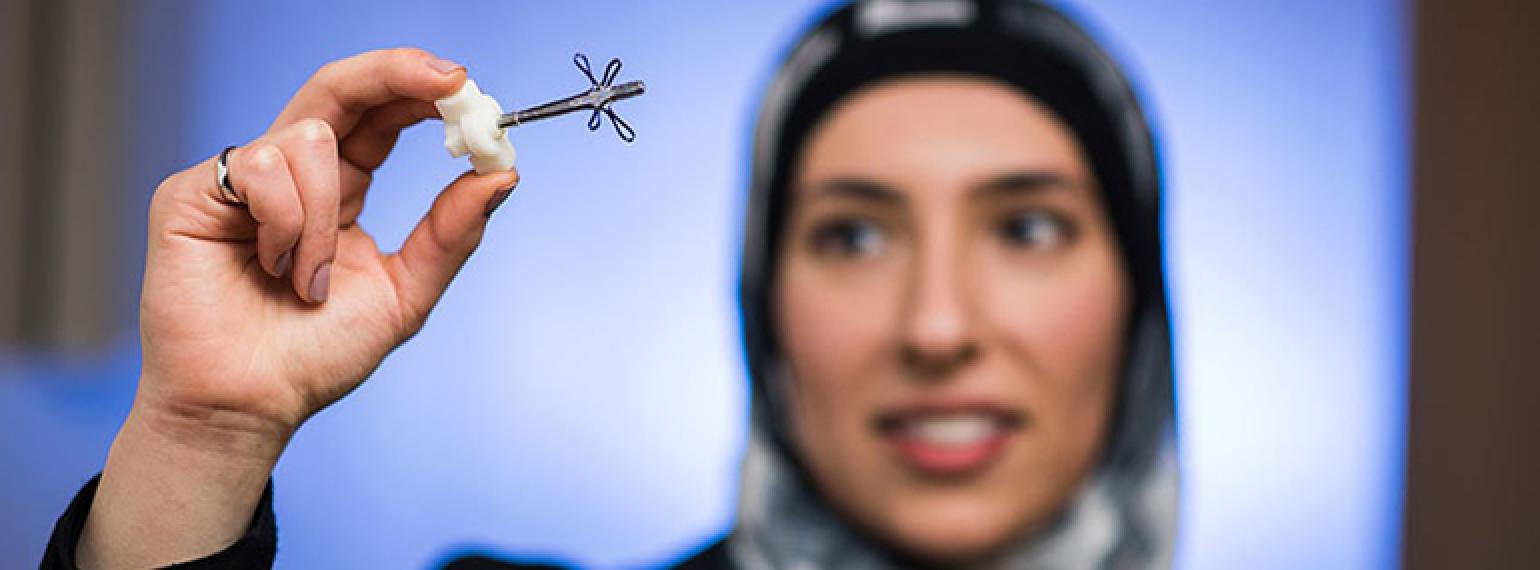 Saja Al-Dujaili, Ph.D., shows a medical device called the Buddy Button