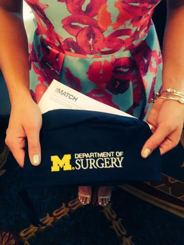 Dr. Valbuena holding a University of Michigan Surgery surgical cap on Match Day