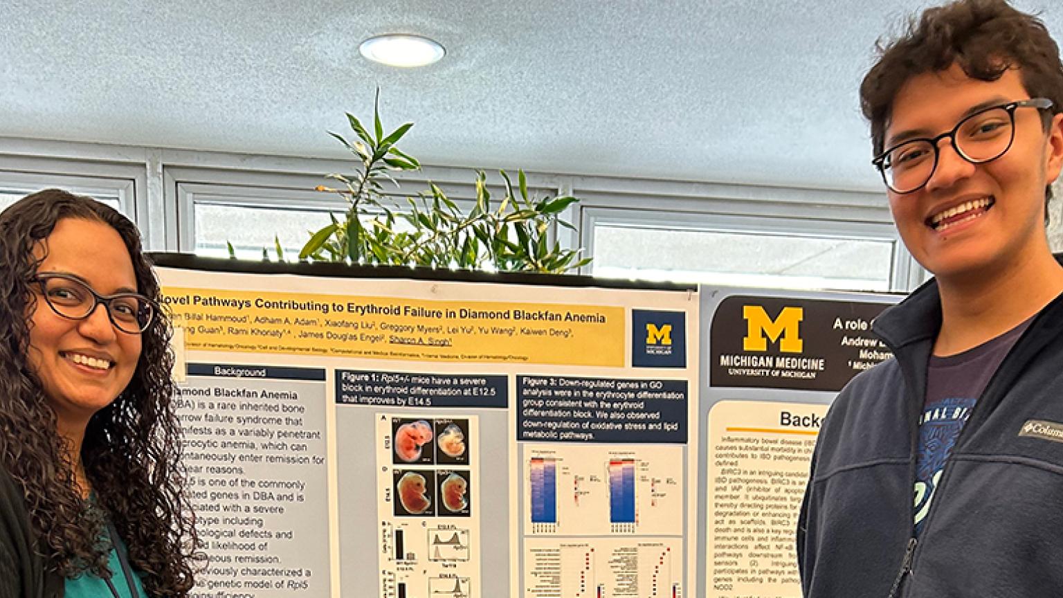 Researcher posing with presentation poster.