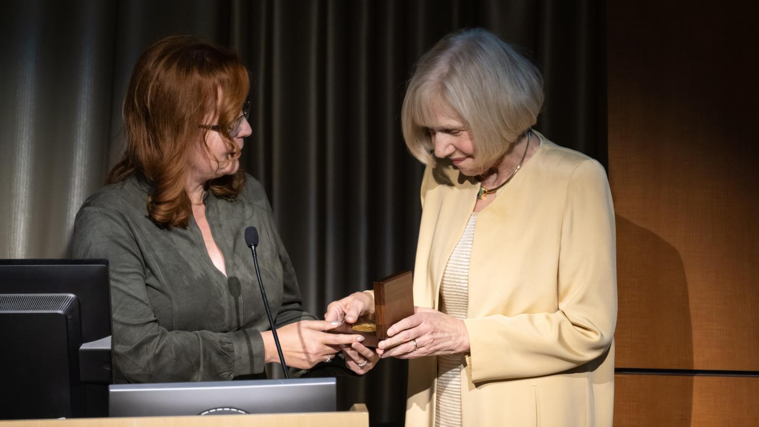 Dr. Eva Feldman receiving a medal from Dr. Dawn Kleindorfer