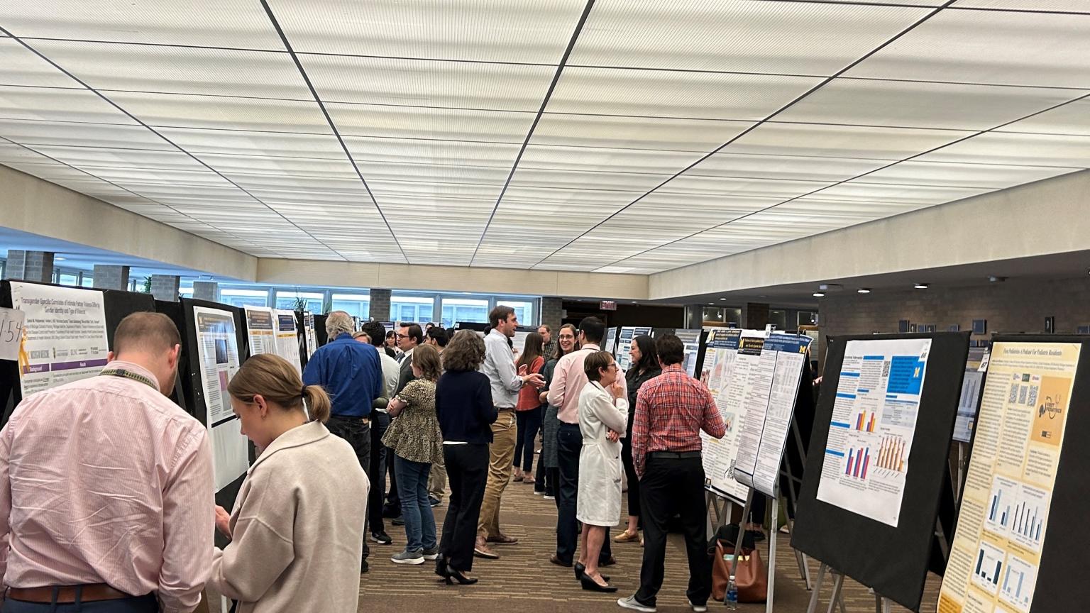 Faculty and trainees surrounded by research posters