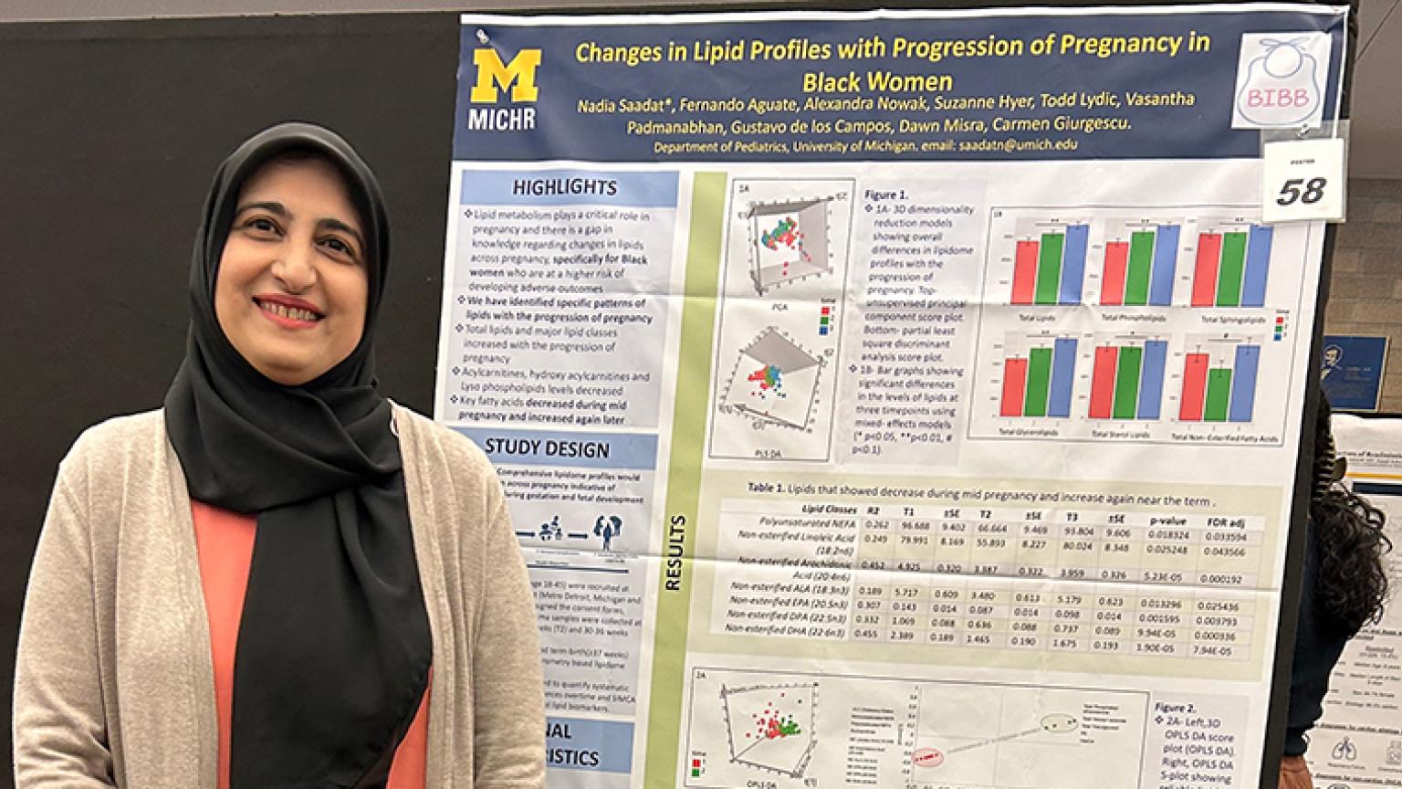 Researcher posing with their presentation poster.