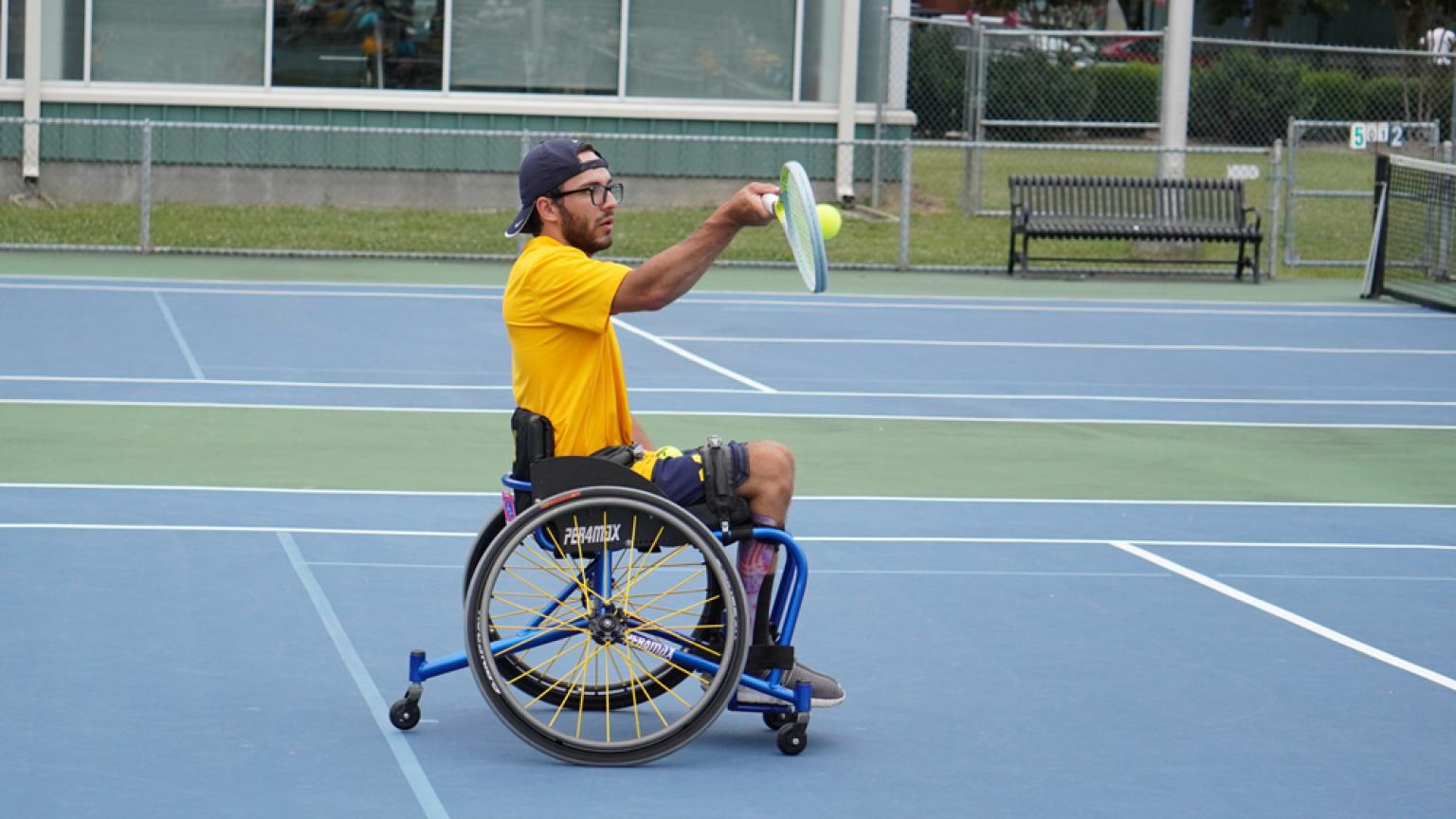 A tennis player in the middle of his game hitting the ball. 