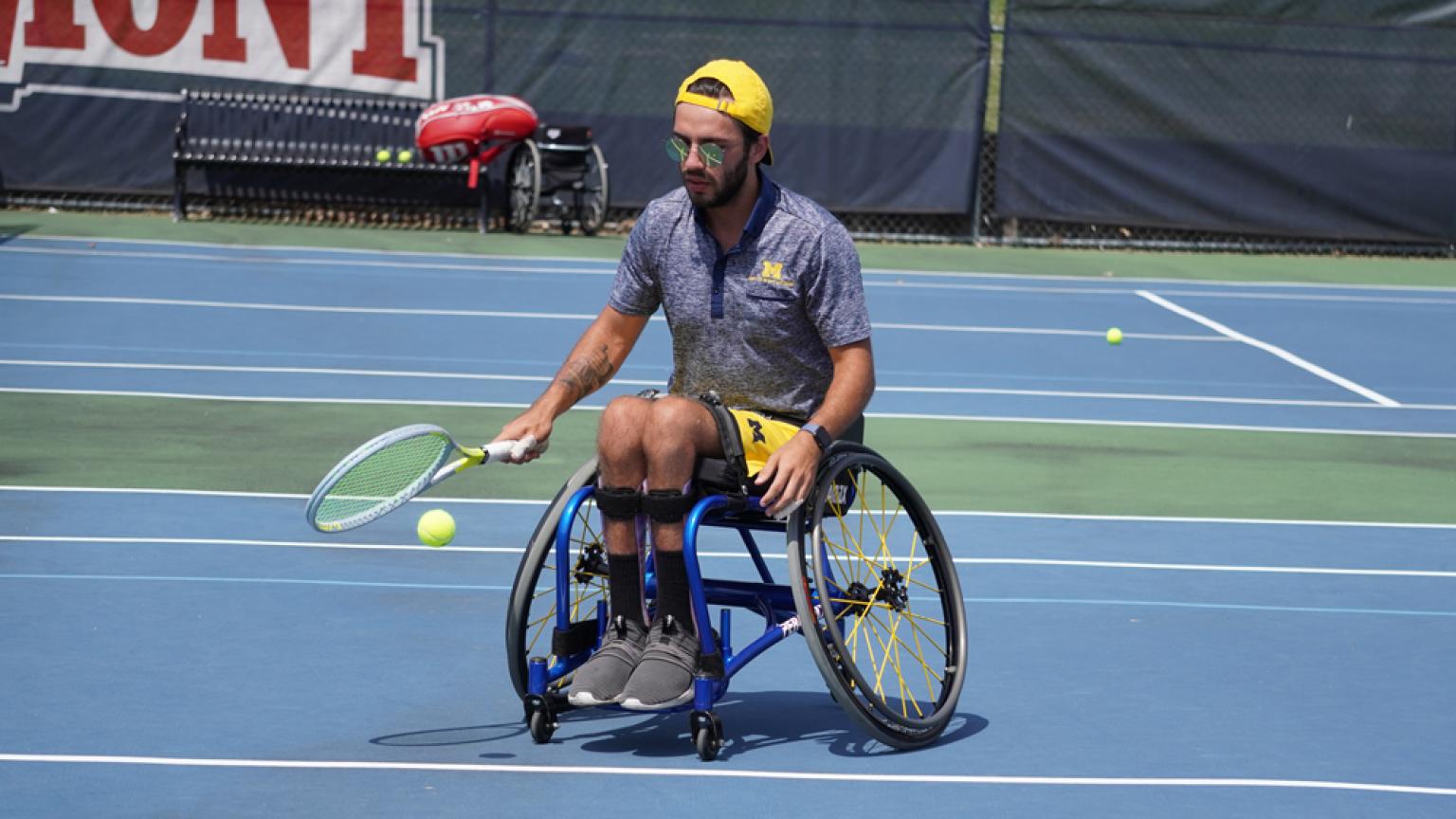 A tennis player practices bouncing the ball to prepare for his game. 