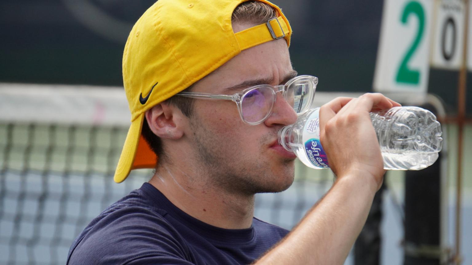 One of the athletes takes a sip of his water after a long day of competition.