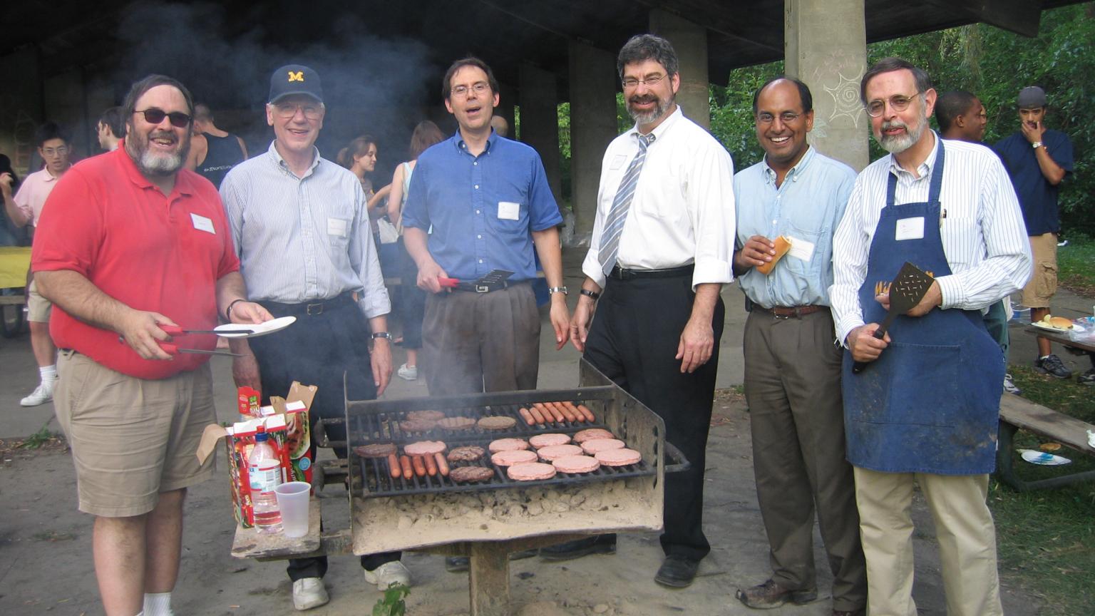 Kent with other Galens faculty standing around a grill 