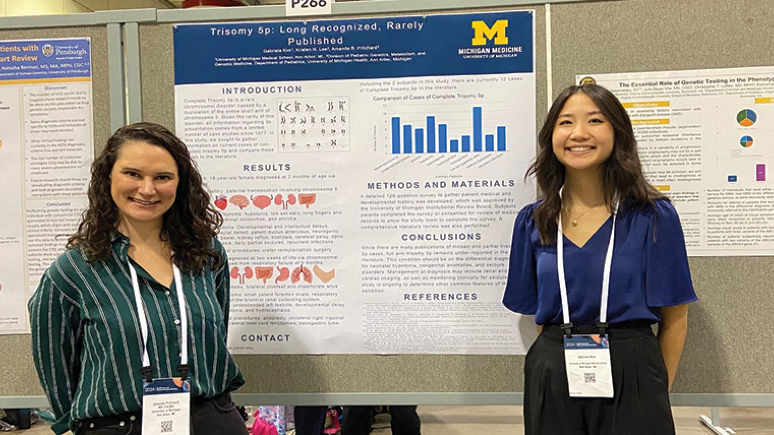 two individuals posing with their research poster