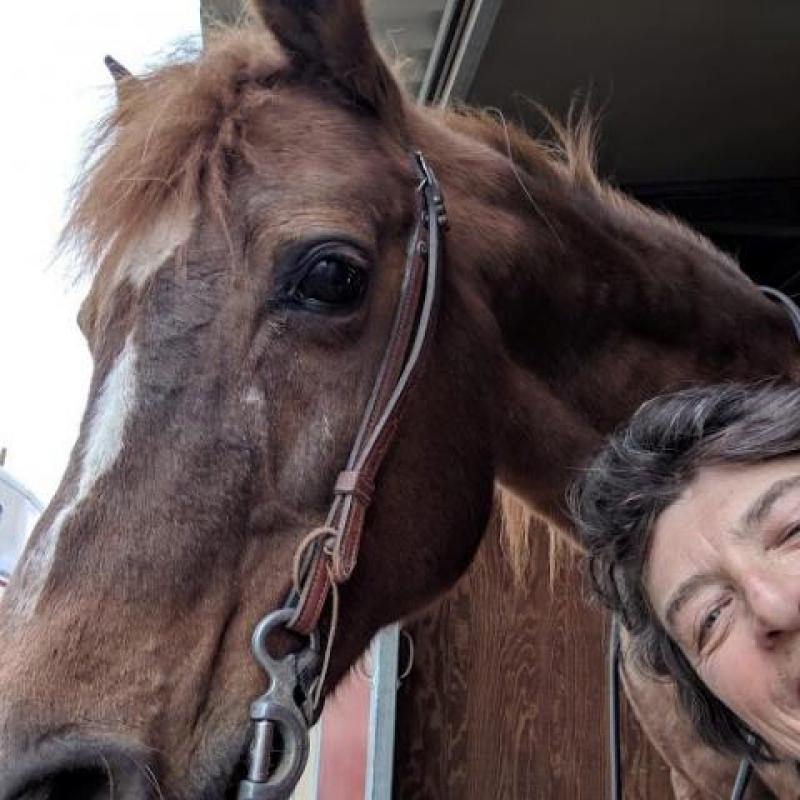 Photo featuring part of Terry's face smiling next to a horse from his horseback therapy riding.