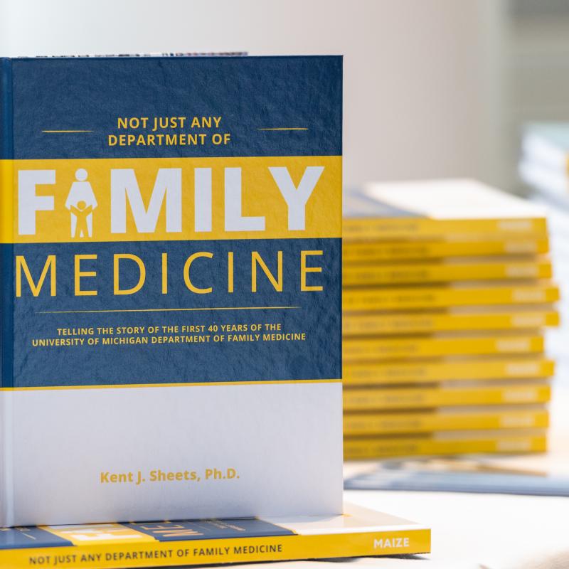 A book entitled "Not Just Any Department of Family Medicine" standing on top of a stack of the same book. 