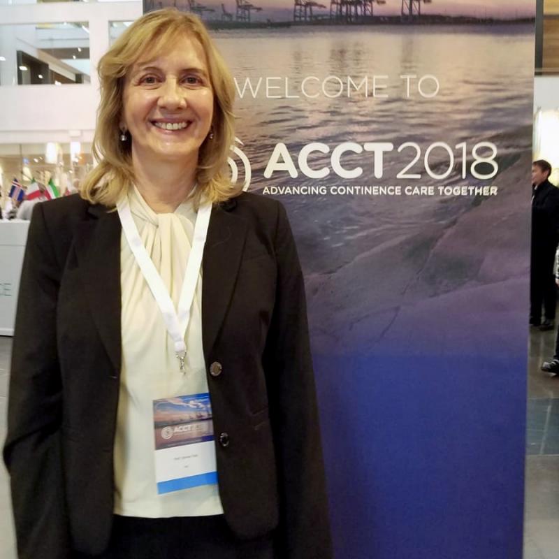 Dr. Tate in front of her poster for the keynote address at ACCT 2018