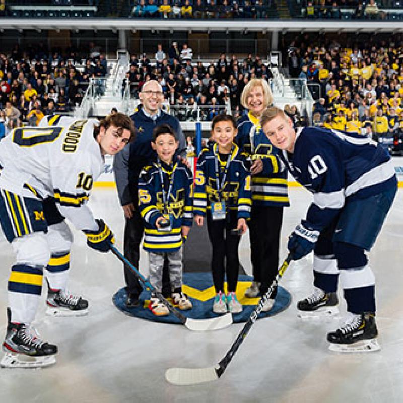 Drs. Goutman and Feldman with Owen and Reese Matzka with U-M and PSU captains