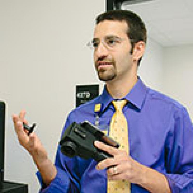 Yannis Paulus, MD, in his lab holding the smartphone/AI system