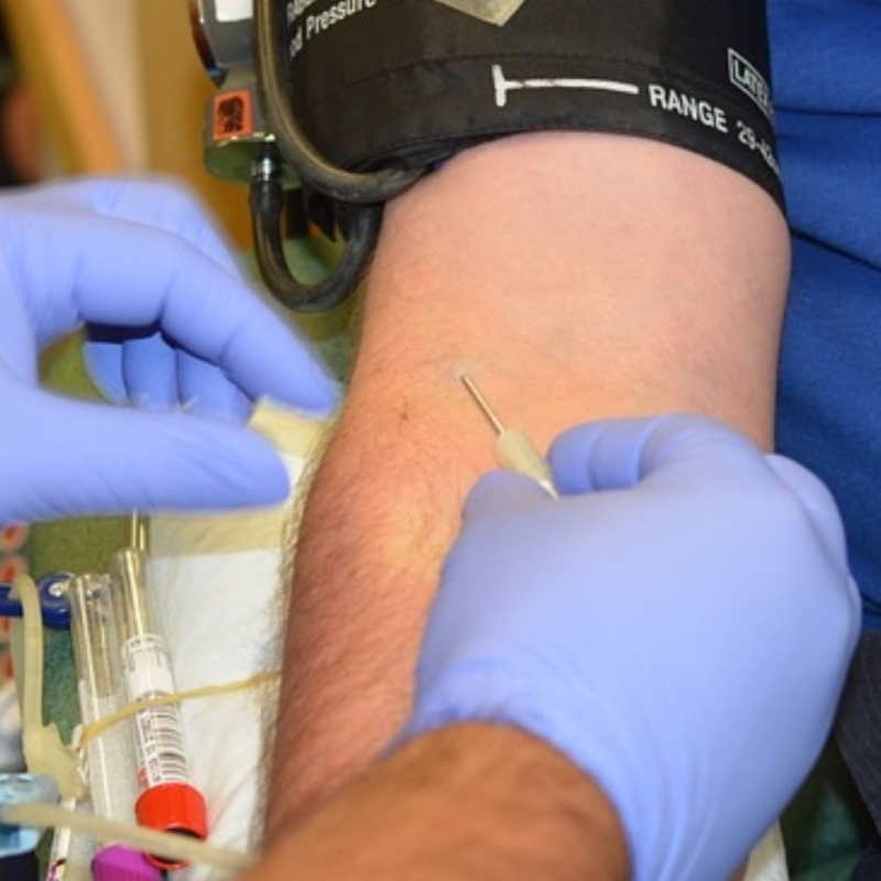 Close up of a man being prepped for a blood draw. 