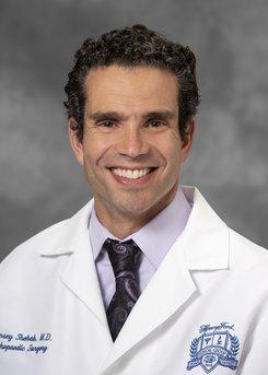 Ramsey Shehab, MD headshot of a white man with brown hair wearing a shirt and tie and white medical coat