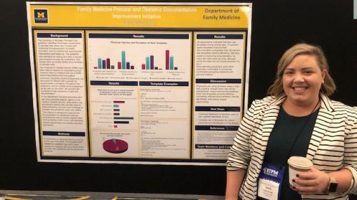 Laura Heinrich stands next to a poster titled Family Medicine Prenatal and Obstetric Documentation Improvement Initiative. 