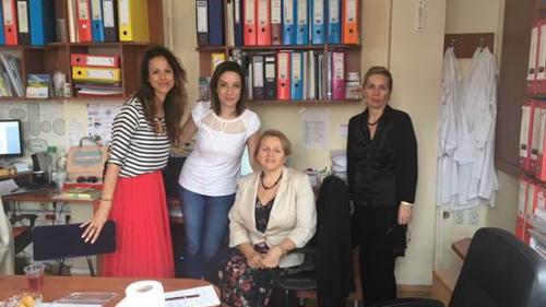 Four women pose in a an office full of files. 