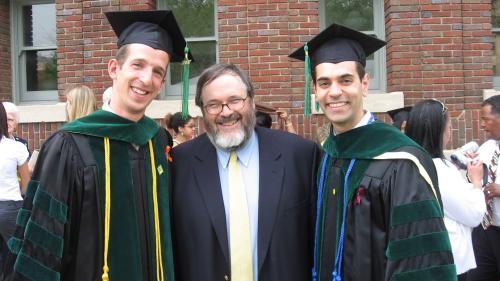 Kent with two medical students wearing caps and gowns
